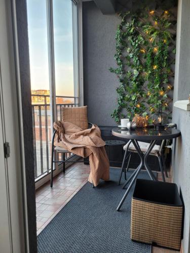 balcone con tavolo e piante di Apartman Riva Parking Garaža a Kraljevo
