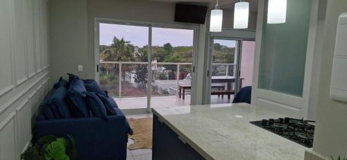 - une cuisine avec un canapé et une table avec vue dans l'établissement Apartamento Novo em São Lourenço, à Bertioga