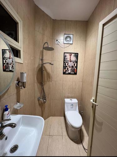 a bathroom with a white toilet and a sink at استديو النورس 4 - بطراز البوهيمي بـ دخول ذاتي in Dammam