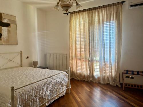 ein Schlafzimmer mit einem Bett und einem großen Fenster in der Unterkunft Brixia Garda Homes in Rezzato
