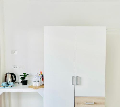 a kitchen with white cabinets and a counter at The Sunset Bangsaen Hotel in Ban Rong Khoei
