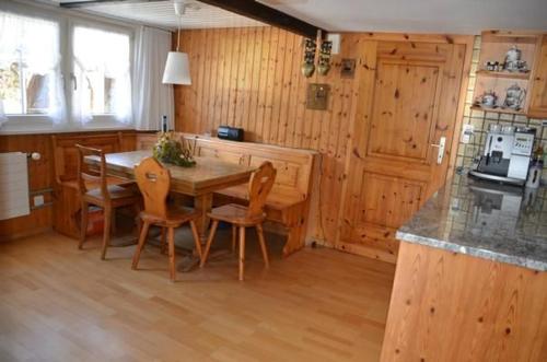 a kitchen with a wooden table and chairs in a room at Breiten in Brunnadern