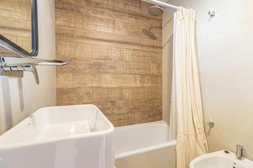 a bathroom with a white tub and a sink at Departamento parque Saavedra in La Plata