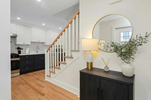 a living room with a staircase and a mirror at Glenbrook Suites in Stamford