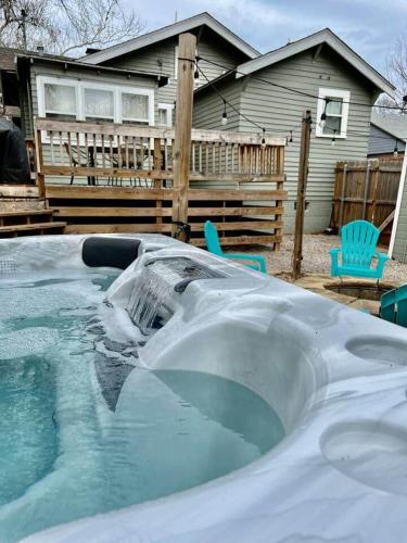 a hot tub with water in front of a house at Owen Bungalow II - OKC Paseo - HOT TUB & Fire Pit in Oklahoma City