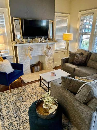 a living room with a couch and a fireplace at Owen Bungalow II - OKC Paseo - HOT TUB & Fire Pit in Oklahoma City