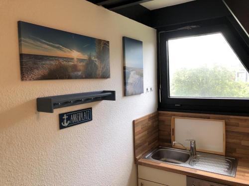 une salle de bain avec un lavabo et une fenêtre dans l'établissement Tossi Haus 107 In Fedderwardersiel, à Butjadingen