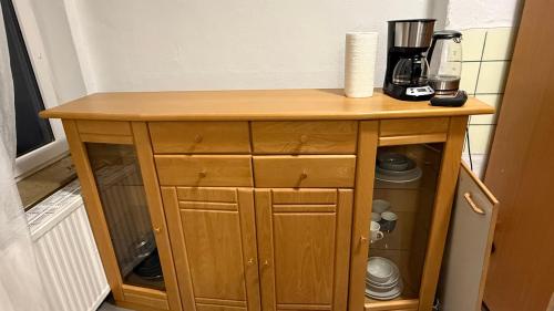 a wooden cabinet in a kitchen with a coffee maker at CCH comfort Bremerhaven in Bremerhaven