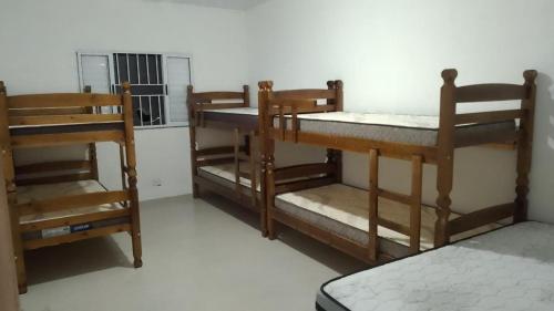 three bunk beds in a room with a window at Chácara Mirante das Colinas in Atibaia