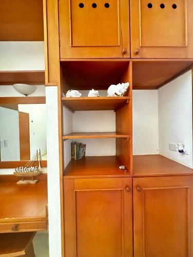 a closet with wooden cabinets and shelves in a room at Beachfront apartment with swimming pool. One bedroom in Celestún