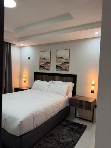 a bedroom with a large white bed and two lamps at EuniBot Guest House in Francistown