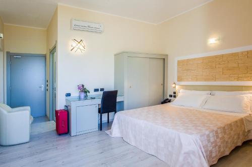 a bedroom with a bed and a desk and a chair at Hotel Calamosca in Cagliari