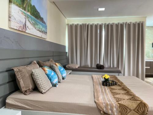 a bedroom with a large bed with pillows at Cobertura com Piscina, Sauna e Churrasqueira in São Pedro da Aldeia