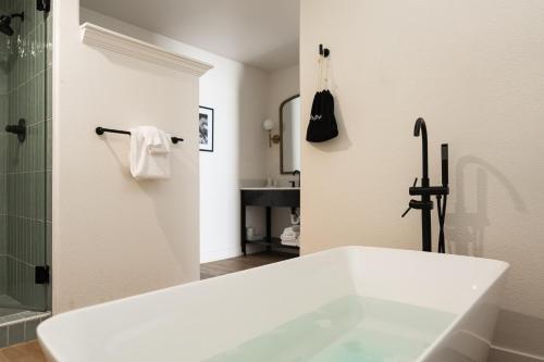 um banheiro branco com banheira e chuveiro em Bodega Coast Inn and Suites em Bodega Bay