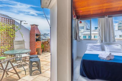 a bedroom with a bed and a table on a balcony at Cobertura posto 5 in Rio de Janeiro