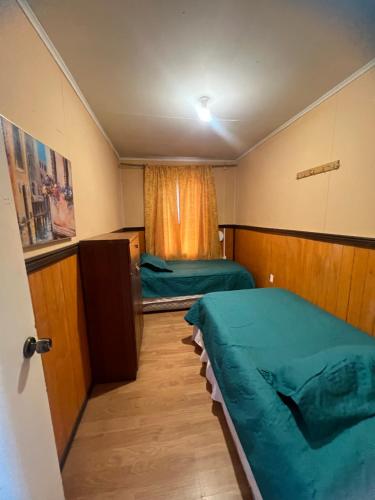 蓬塔阿雷纳斯Casas por día Punta Arenas的有两张床和一扇窗户的小房间