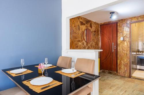 a dining room with a black table and chairs at Cobertura posto 5 in Rio de Janeiro