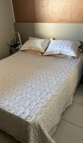 a bed with white sheets and pillows on it at Enjoy summer with the family on Camboinha beach in Cabedelo