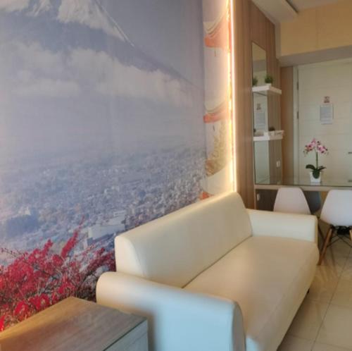 a living room with a couch and a painting on the wall at The Asando Above Pakuwon Mall in Lontar