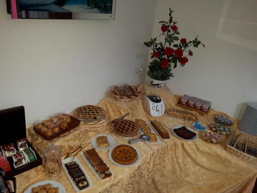 a table with cookies and pastries and a vase of flowers at Bed and Breakfast Coral Blue in Briatico