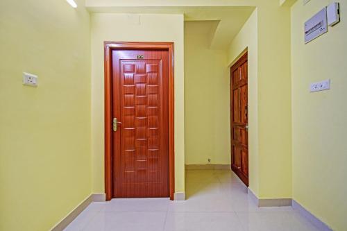 un pasillo vacío con una puerta roja en una habitación en Hotel O Maa Residency Near Biswa Bangla, en Thākurdwari