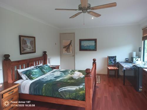 a bedroom with a bed and a ceiling fan at Quand0ng Valley Inn The Waterfall Room in Minynon