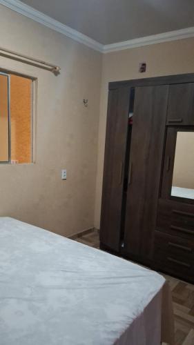 a bedroom with a bed and a wooden cabinet at Casa das dunas in Prea