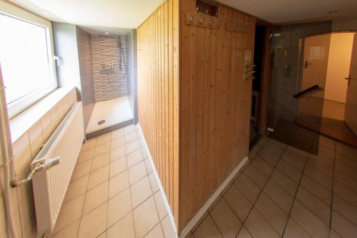 a hallway with a wooden paneled wall and a window at Naturpur Ferienhaus in Friedrichsbrunn