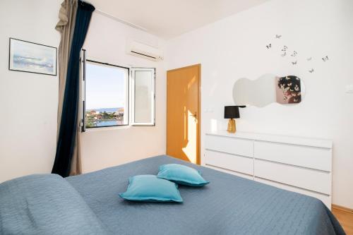 a bedroom with a blue bed with two pillows at Seaside family friendly house with a swimming pool Drvenik Veliki, Drvenik - 22085 in Veliki Drvenik