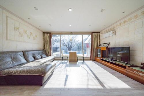 a large living room with a couch and a tv at Hue Bless Spa Pension Gapyeong in P'yŏngban-ni
