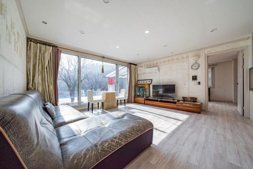 a large living room with a couch and a television at Hue Bless Spa Pension Gapyeong in P'yŏngban-ni