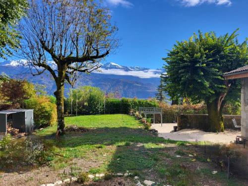 un cortile con un albero e montagne sullo sfondo di Naëlo Chartreuse a Biviers