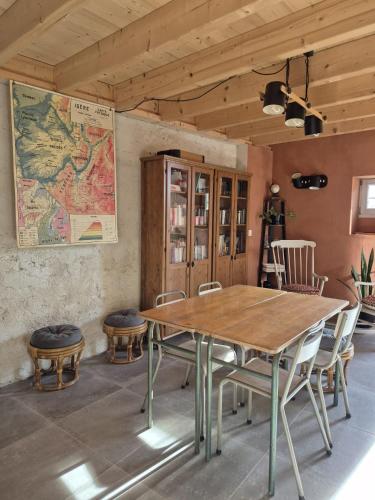 un tavolo e delle sedie in una stanza con una mappa sul muro di Naëlo Chartreuse a Biviers