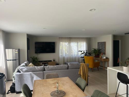 a living room with a couch and a table at Peaceful house in Kumeu