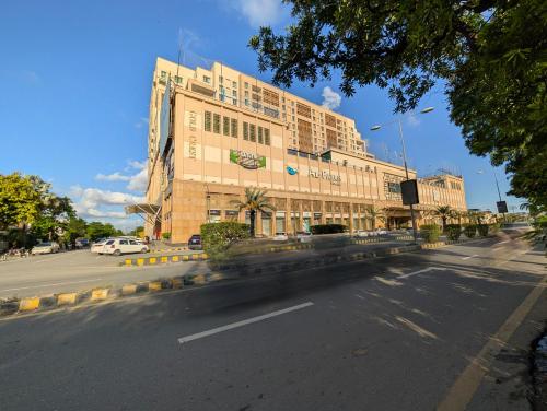 a large building on a city street with a road at Goldcrest Alfatah Mall - DHA Phase 4 - Luxury Apartments by Alvis Suite in Lahore