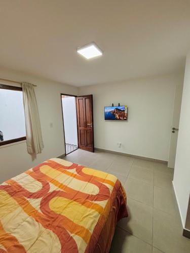 una camera da letto con un letto e una TV a parete di Complejo Malagi a Barrio Félix U Camet