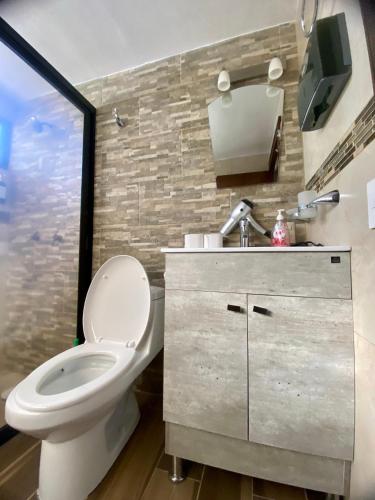 a bathroom with a toilet and a sink and a window at Casa Luca in Mazamitla
