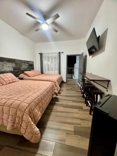a bedroom with two beds and a ceiling fan at Hotel Cuatro Palmas in Puerto Peñasco