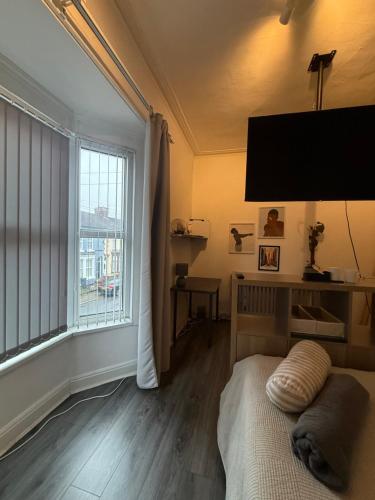 a bedroom with a bed and a large window at Home From Home in Liverpool