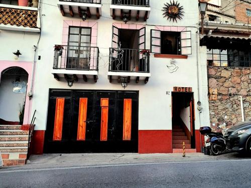 a building with orange doors on the side of it at Hotel Las Palomitas in Taxco de Alarcón