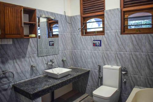 a bathroom with a sink and a toilet at Royal Villa Polhena in Matara