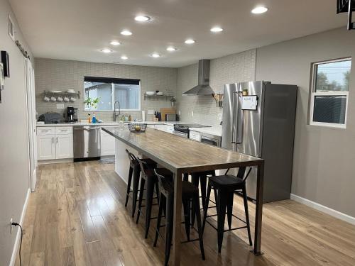 a large kitchen with a table and a refrigerator at Modern Art House in Midtown, Pet Friendly in Phoenix