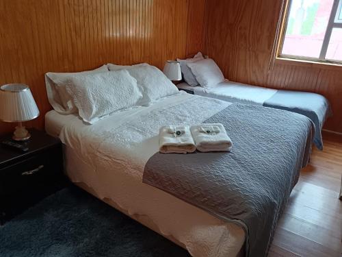 纳塔列斯港Hostal Reymar的卧室里有一张床，床上放着两条毛巾。