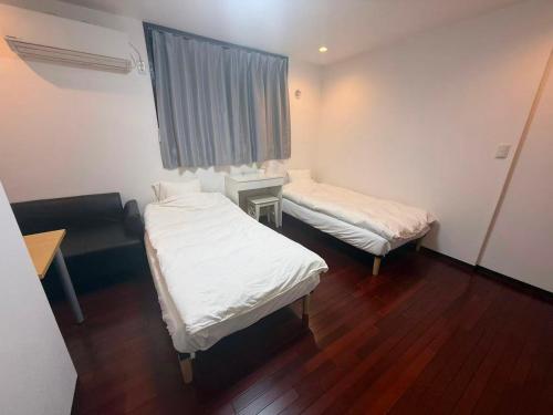 Ένα ή περισσότερα κρεβάτια σε δωμάτιο στο 東京BnBホテル