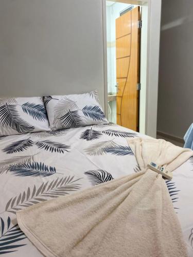 a bed with black and white sheets and pillows at Eds pousada in Juazeiro do Norte