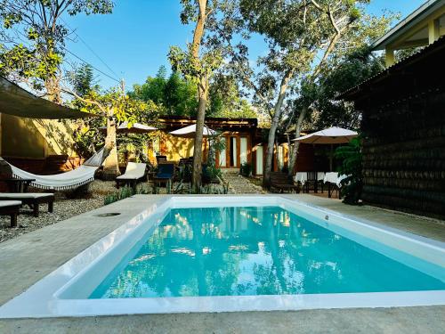 a swimming pool in front of a house at Punta Surf Cabañas & Glamping in Brisas de Zicatela