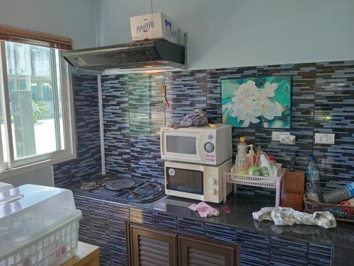 Una cocina con un microondas encima de una encimera. en บ้านเพื่อนโฮมสเตย์, en Ban Muang (1)