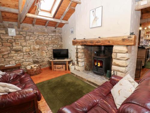 a living room with a couch and a fireplace at The Granary in Morpeth