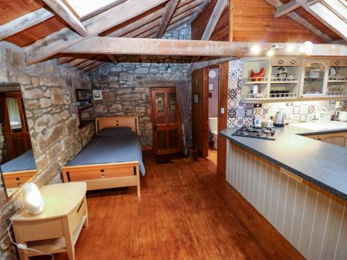 a room with a bed and a kitchen in a house at The Granary in Morpeth