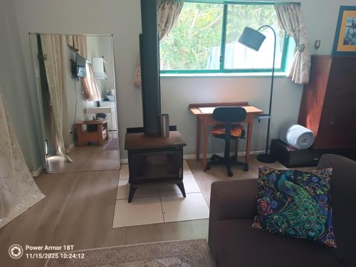 MinynonにあるQuandong Valley Innのソファとストーブとテーブルのあるリビングルーム